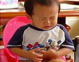 photo f a boy toddler sitting on the pot grunting in need of constipation relief