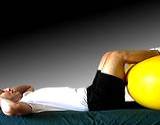 photo of man laying on back with legs on exercise ball to relive pain of herniated disk
