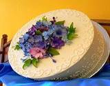 A double layer caked frosted and a bouqet of edible flowers in the center