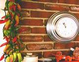 Italian kitchen red brick wall, clock and dried peppers hanging