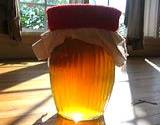 photo of a glass container full of kombucha tea sitting on a table in the sunlight