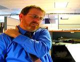 photo of man working in office rubbing shoulder for neck pain relief