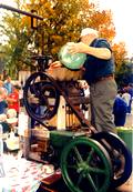 A photo of a man pour apples into an apple cider press