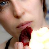 photo of a woman eating an apple promotes cavity prevention