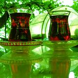 photo of two tall glasses of ice black tea sitting outdoors