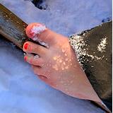 photo of a woman's bare foot in the snow a natural remedy for cold feet