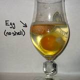 photo of eggs soaking in a glass wine glass full of rice vinegar