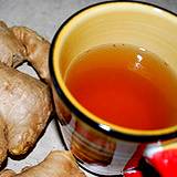 photo of a cup of ginger tea and ginger root