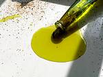 photo of pouring olive oil that is green in color onto a table sheet