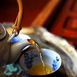 photo of herbal tea pot pouring a cup of herbal tea as an excellent source for natural hair loss