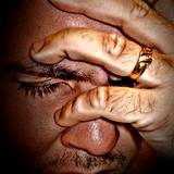 photo of man holding head symptom of neck pain