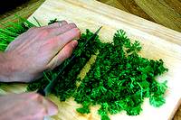 photo of parsley being chopped on a chopping block
