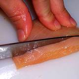 photo of raw chicken being sliced a likely source of salmonella poisoning