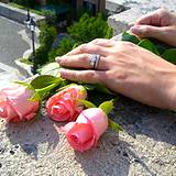 a photo of a woman's hands adjusting pick rose buds
