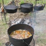 homemade soup cooking outdoors in cast iron pot