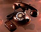 photo of an old black Bell telephone sitting next to a cell phone showing technology has come a long way