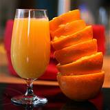 photo of a stack of orange peels beside a glass of orange juice for natural allergy relief