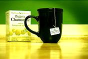 photo of a box of store bought Chamomile Tea with black tea cup beside it