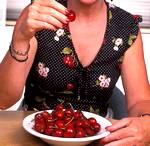 women eating a plate full of cherries