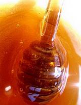 photo of honey dripping off a honey-dipper